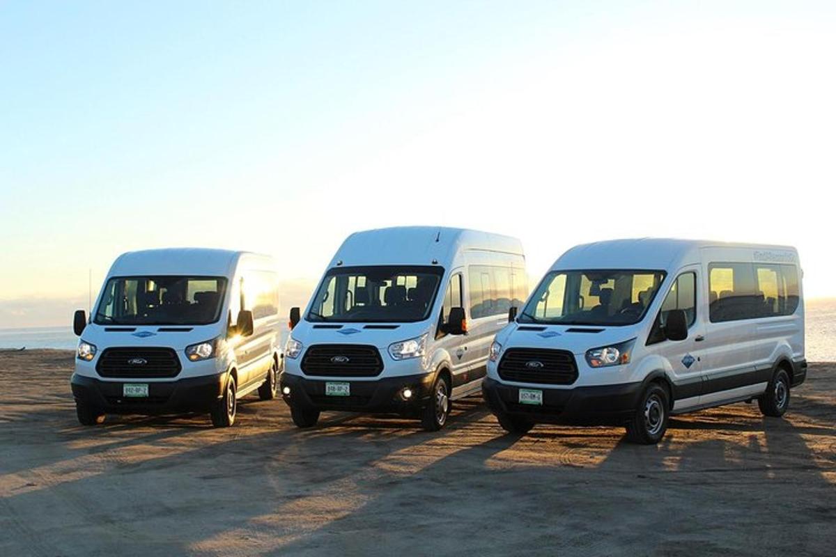 Tres furgonetas blancas estacionadas en un estacionamiento