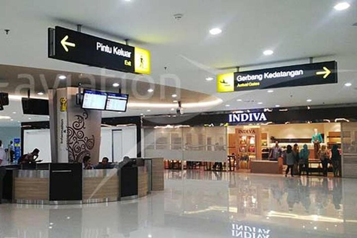 a lobby of an airport with people walking around