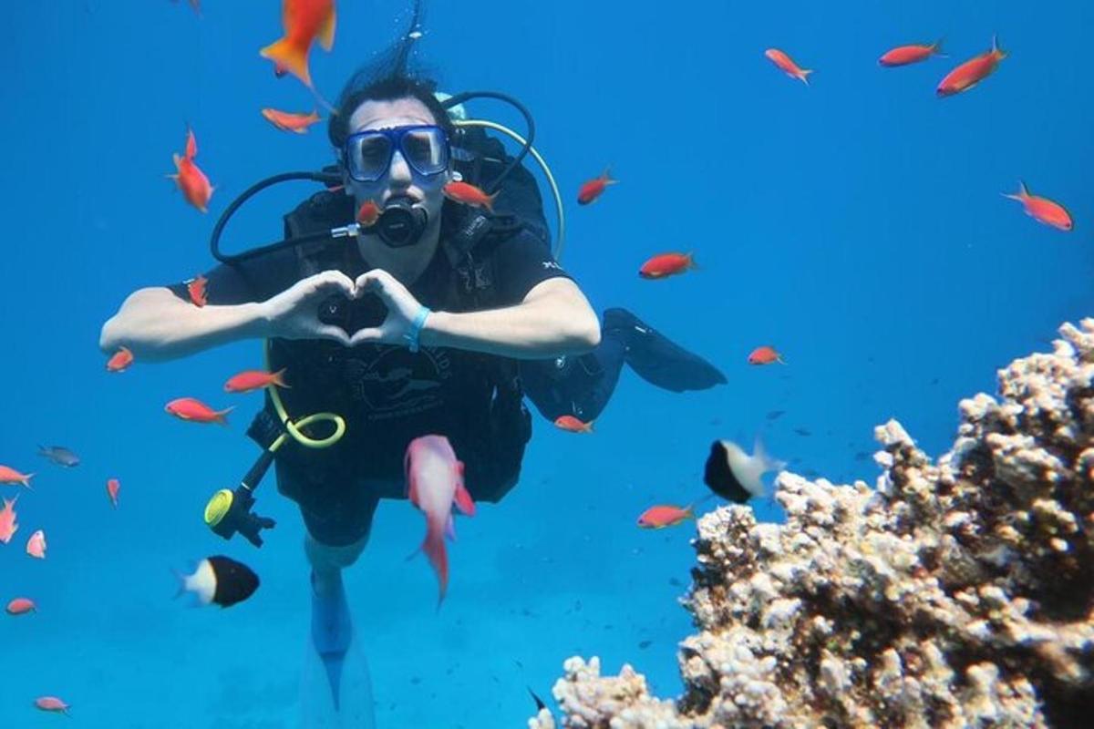 muž dělá znamení srdce při potápění v oceánu