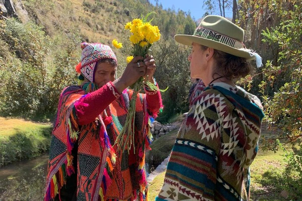 due donne sono in piedi accanto a un fiume con in mano dei fiori