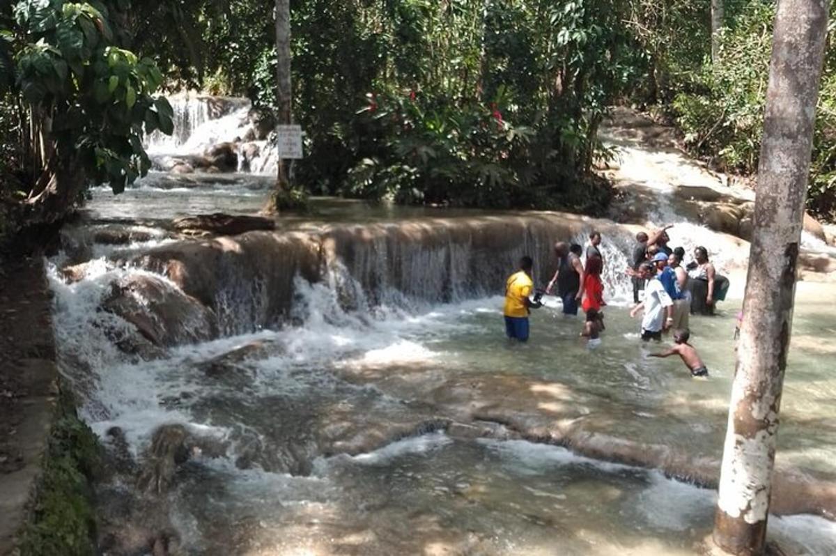 un gruppo di persone in piedi nell'acqua vicino a una cascata
