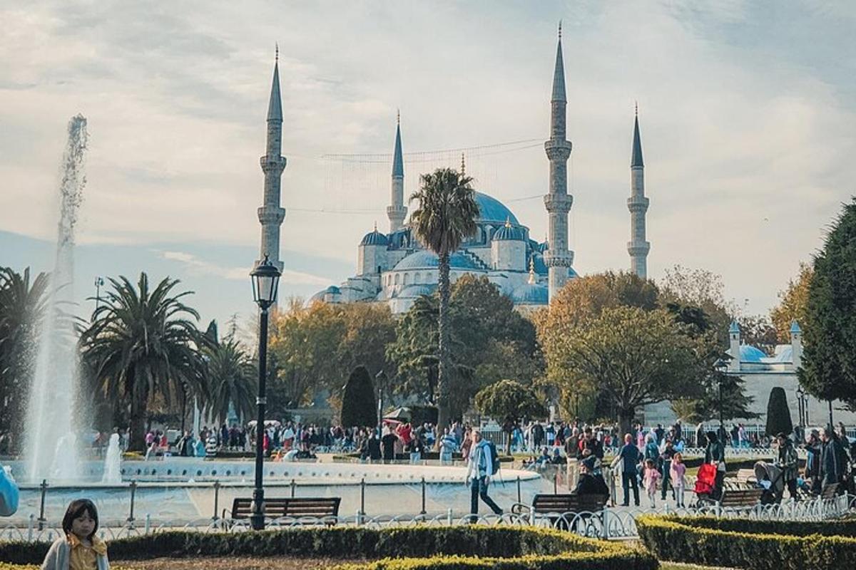 ένα πλήθος ανθρώπων που περπατούν μπροστά από ένα τζαμί