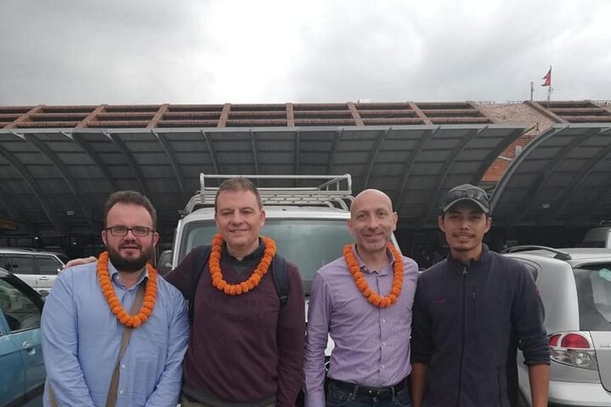 a group of three men standing in front of a parking lot