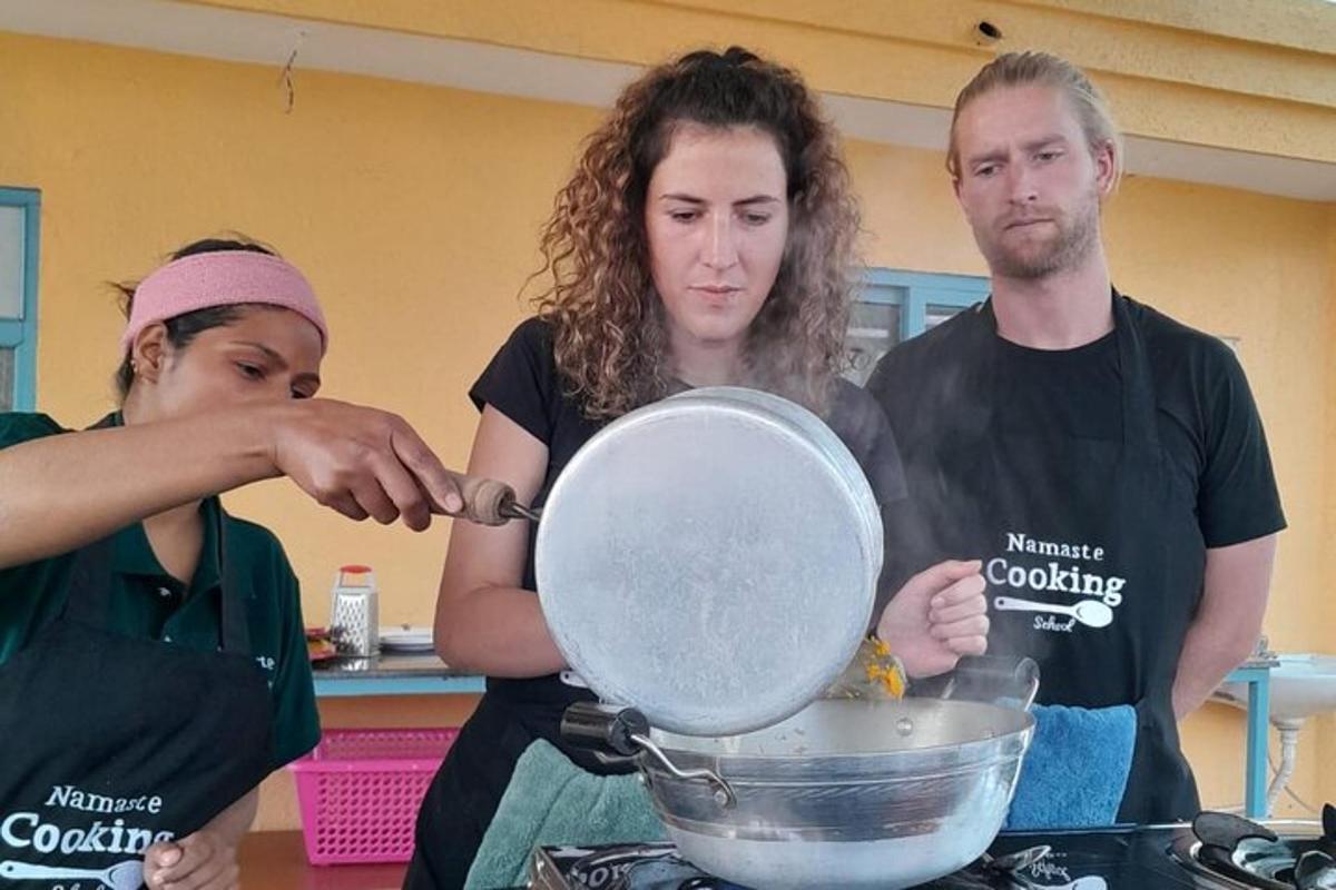 two women and a man preparing food in a kitchen