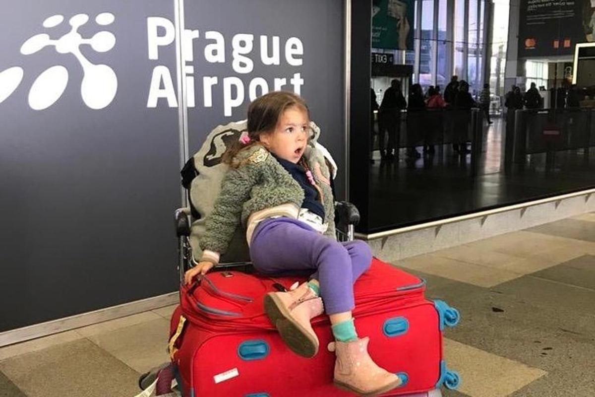 maža mergaitė, sėdinti ant bagažo krūvos