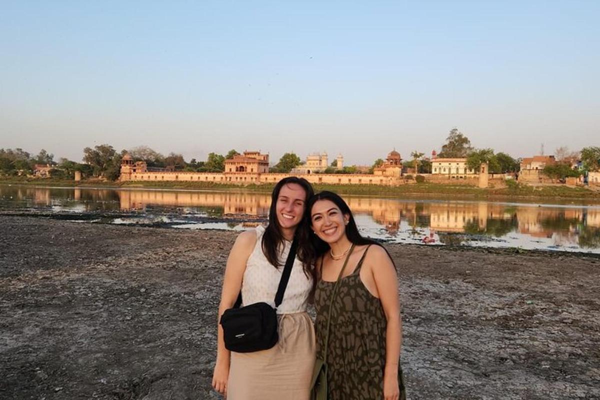 two women standing in front of a body of water