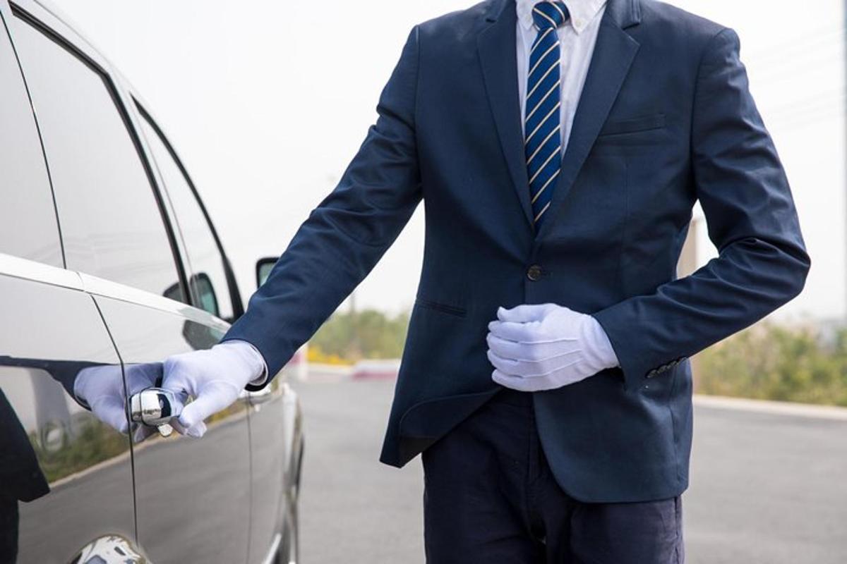 a man in a suit and tie is opening a car door