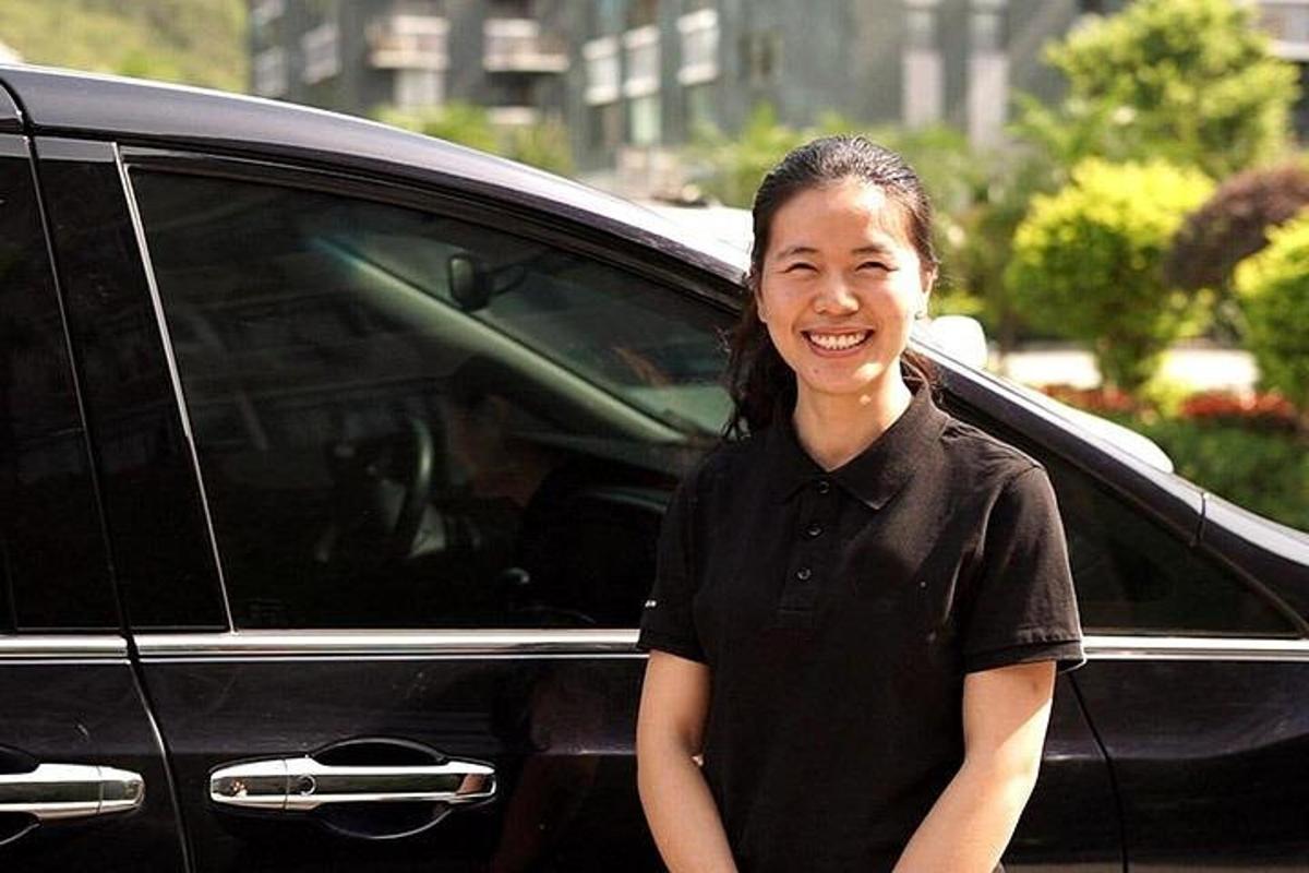 a woman standing in front of a black car