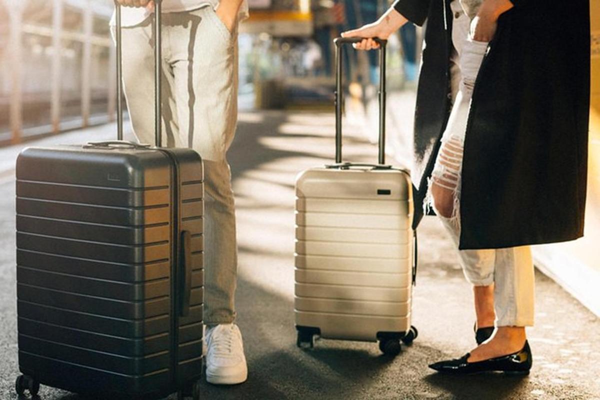 двоје људи стоје са пртљагом на улици