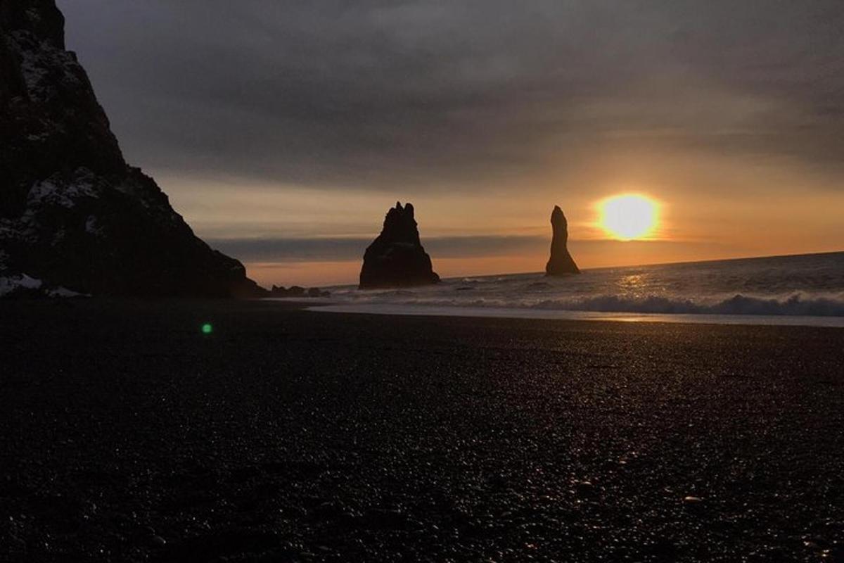 sončni zahod na plaži s skalami v oceanu
