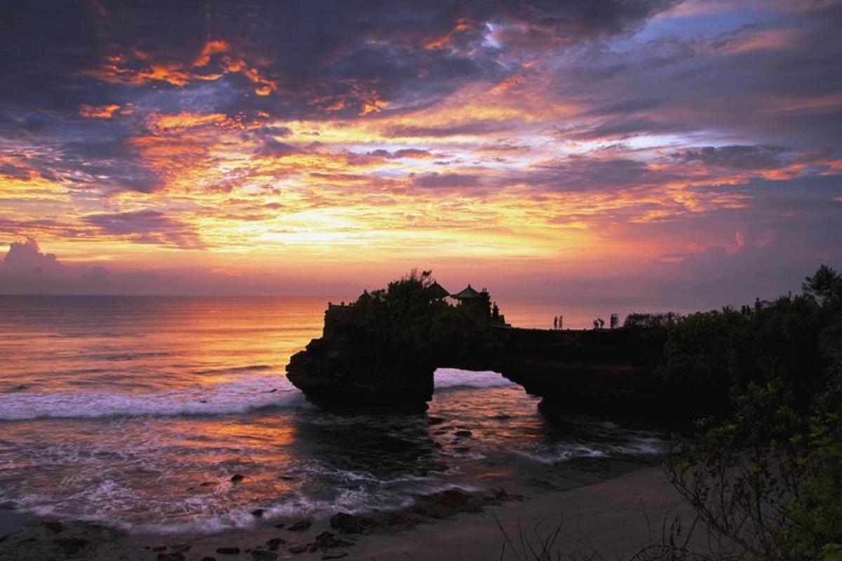 un tramonto sull'oceano con una roccia nell'acqua