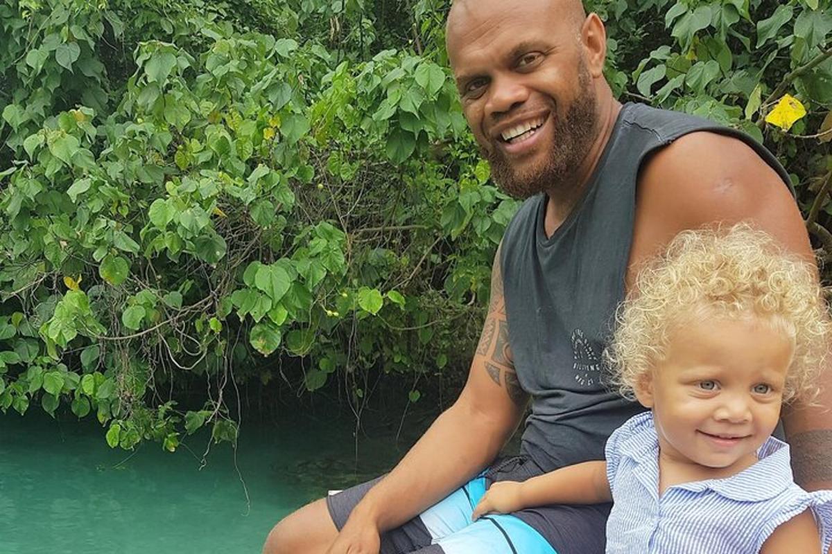 a man and a child sitting next to a body of water