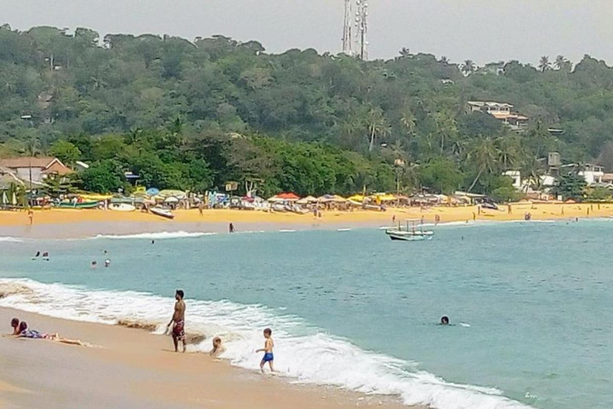 a group of people playing in the water at the beach