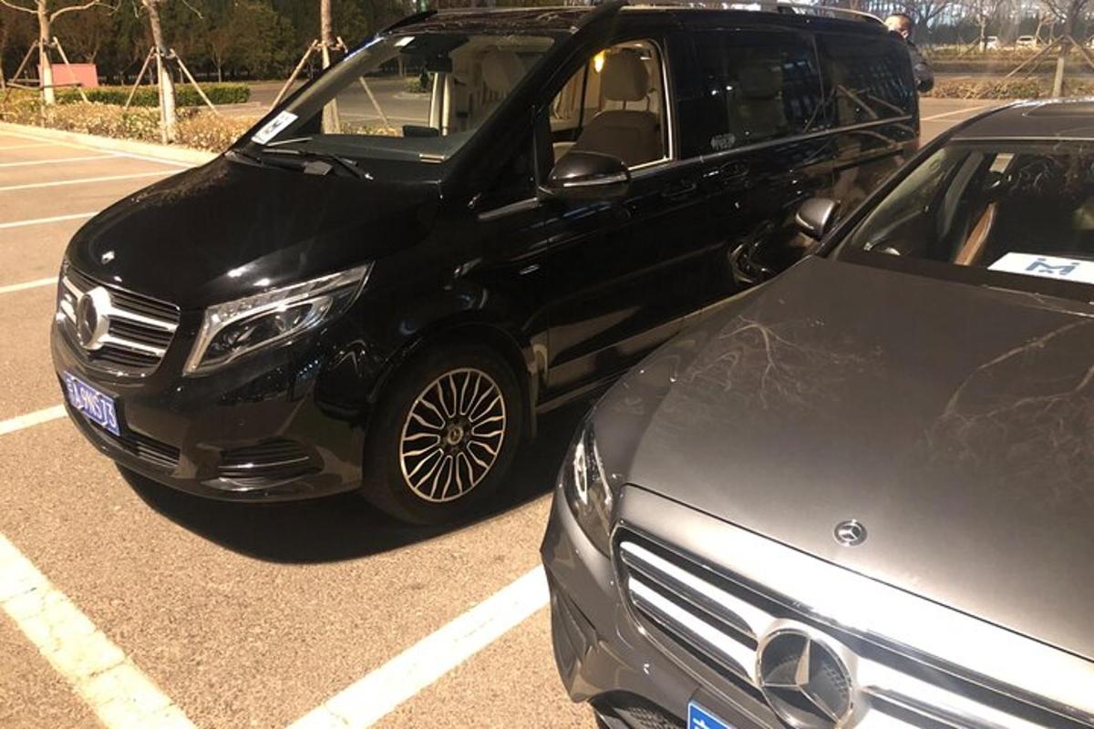 ein schwarzer SUV und ein schwarzes Auto auf einem Parkplatz geparkt