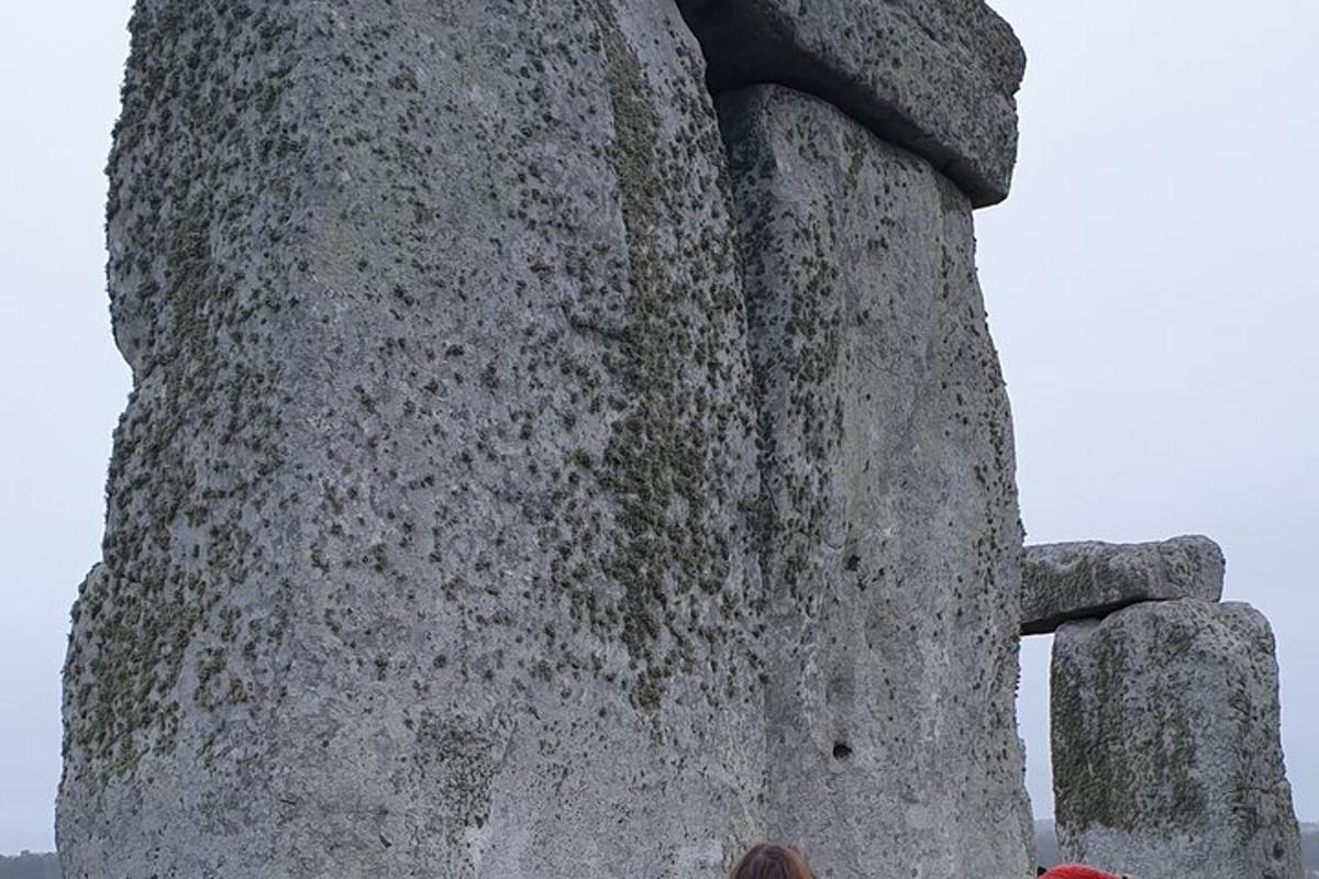 osoba stojící vedle velké kamenné stavby