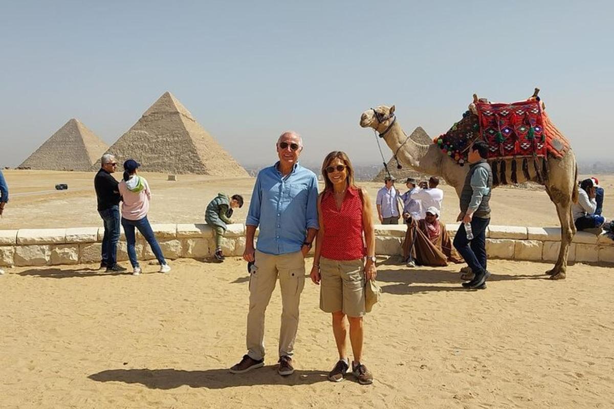 a man and woman standing in front of the pyramids