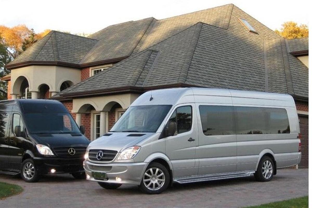 two vans parked in a parking lot in front of a house