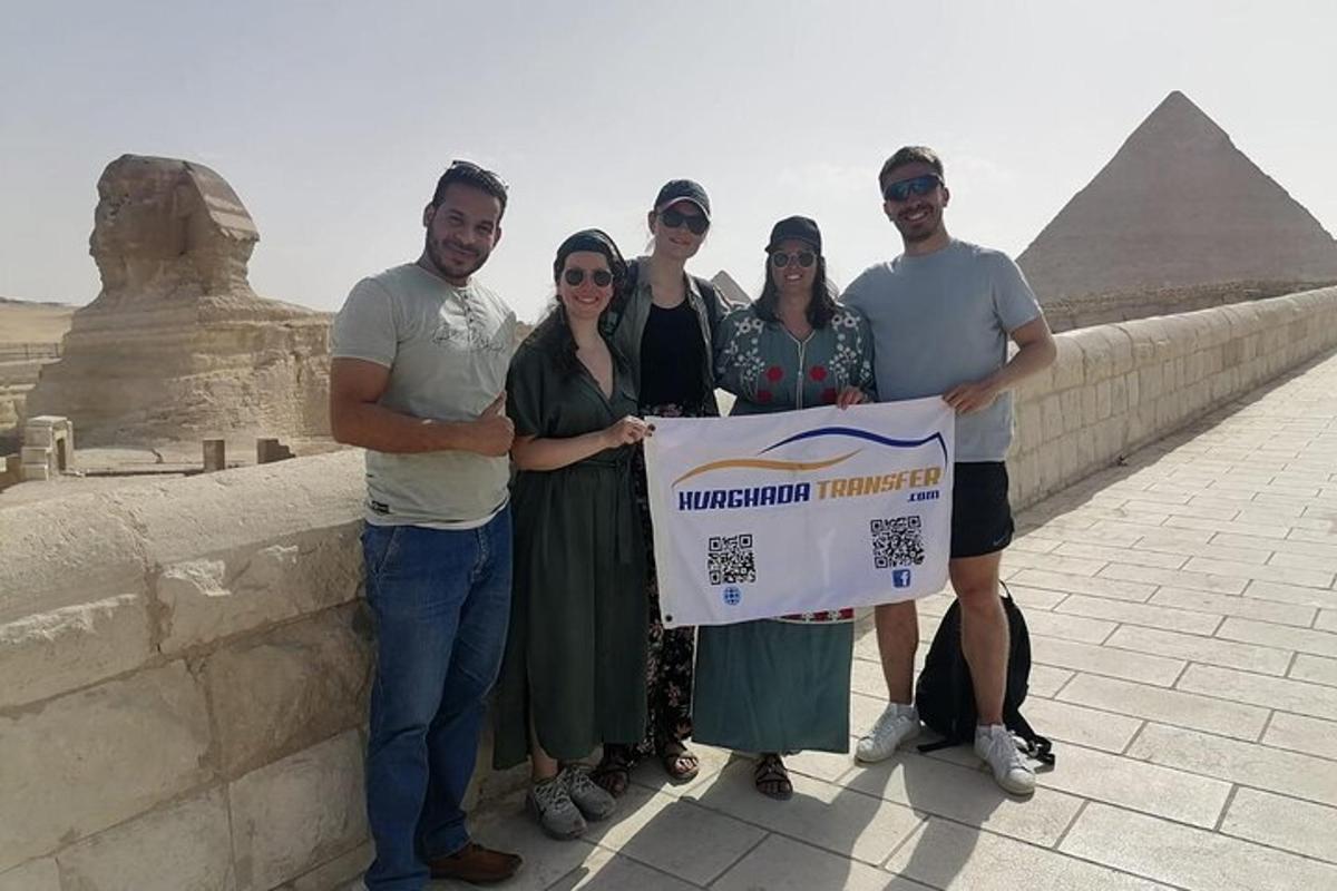 skupina lidí držících ceduli před pyramidou