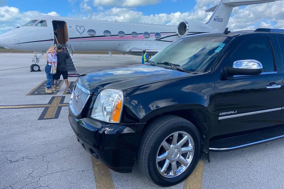 a black truck parked in front of an airplane