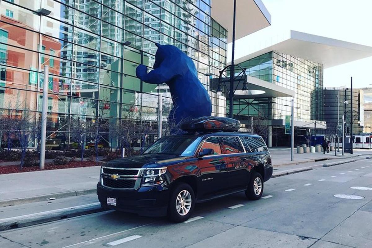 Una camioneta estacionada en una calle con una estatua de un oso azul en el techo.