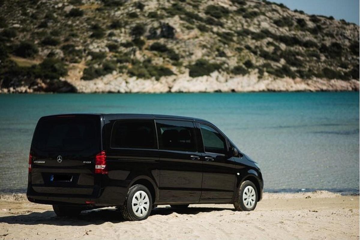 en svart SUV parkert på stranden nær vannet
