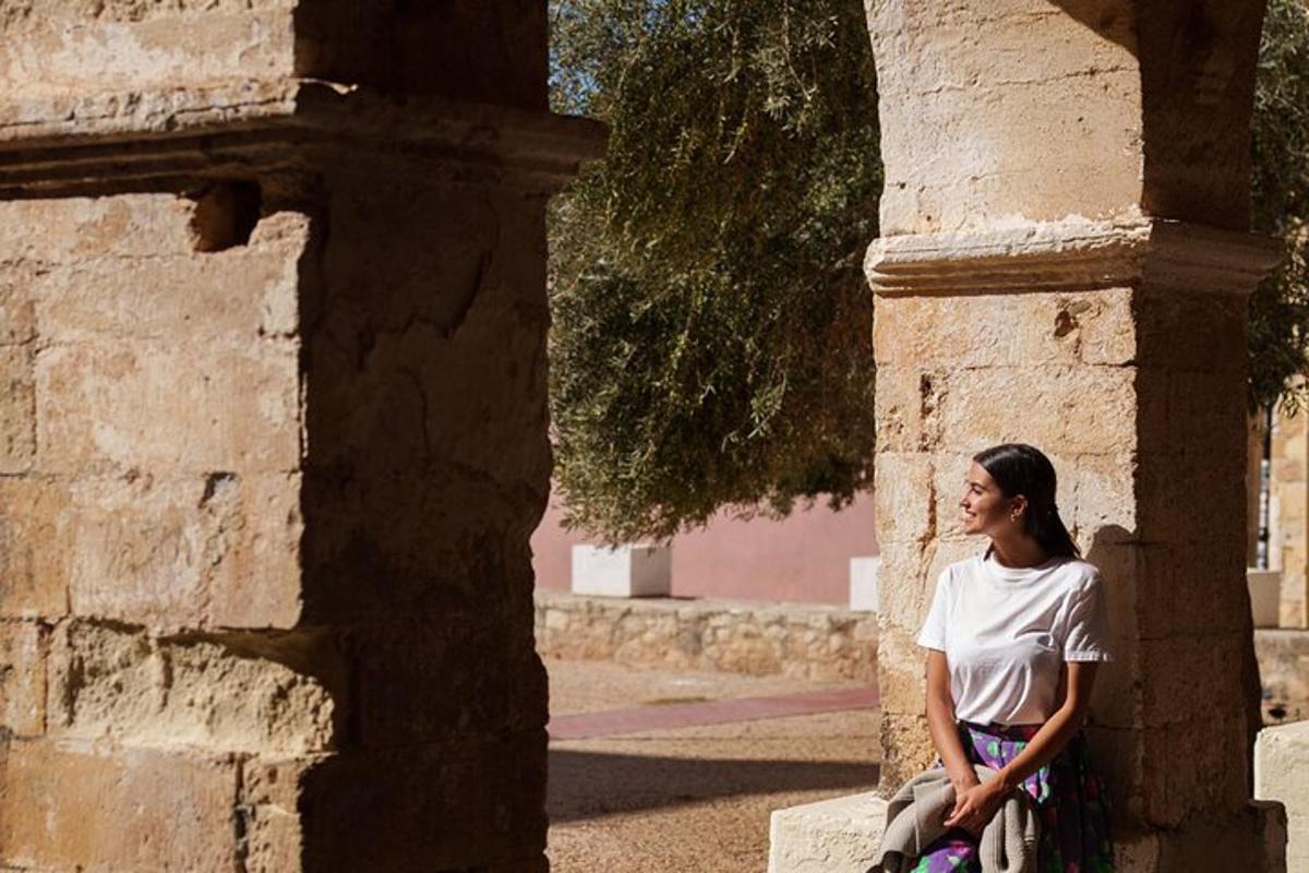 uma mulher sentada em um pilar de um prédio