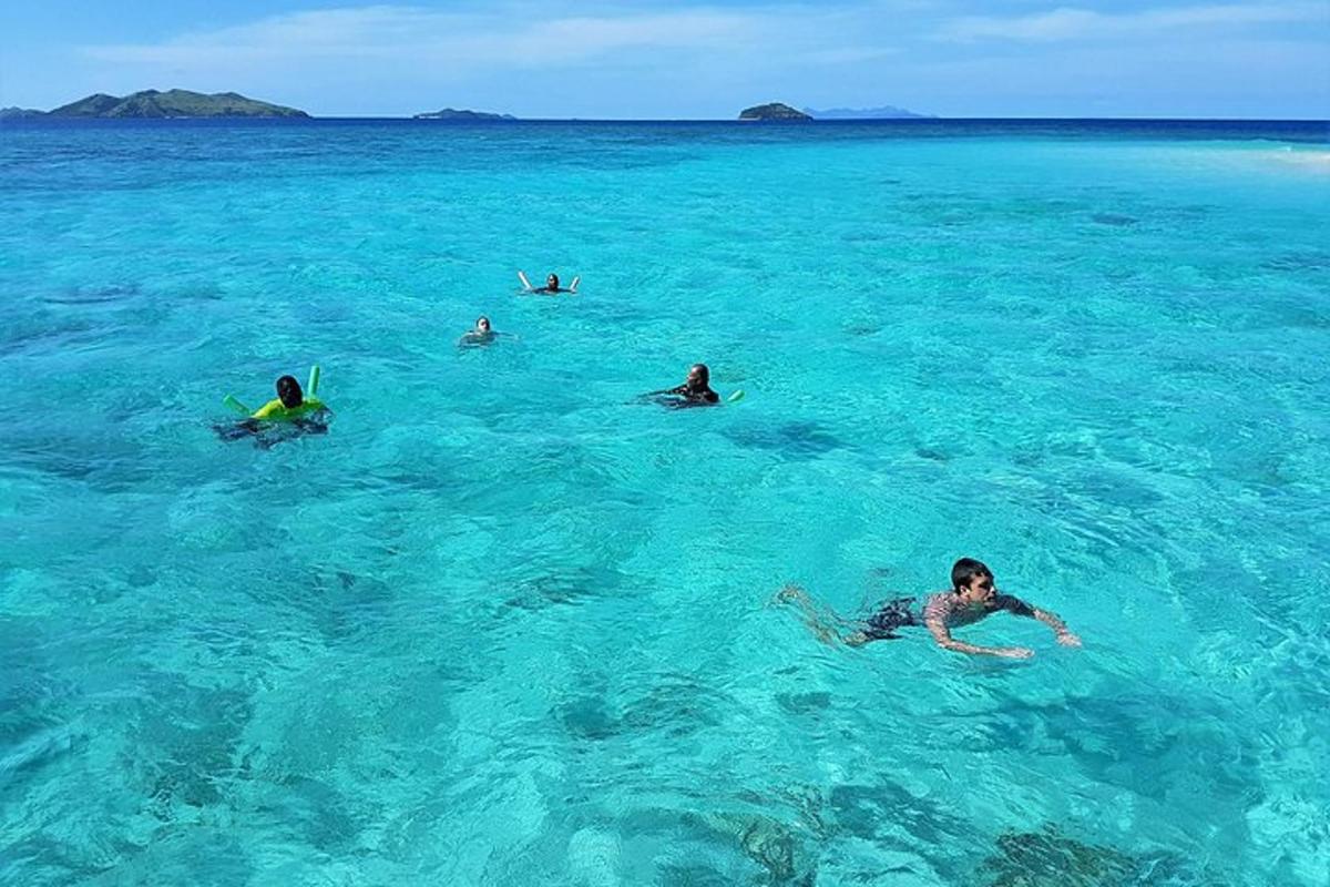 a group of people swimming in the blue ocean