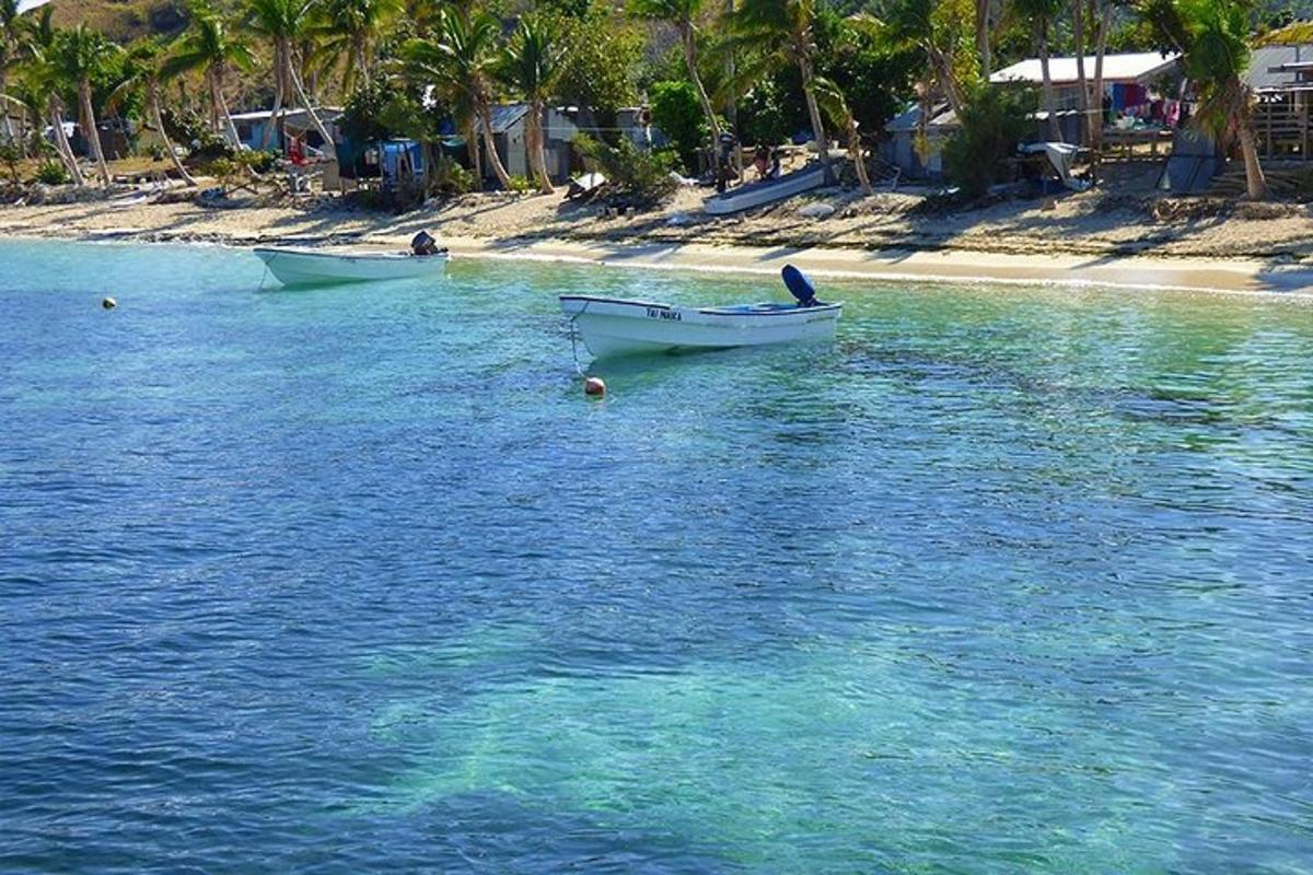 two boats in the water next to a beach