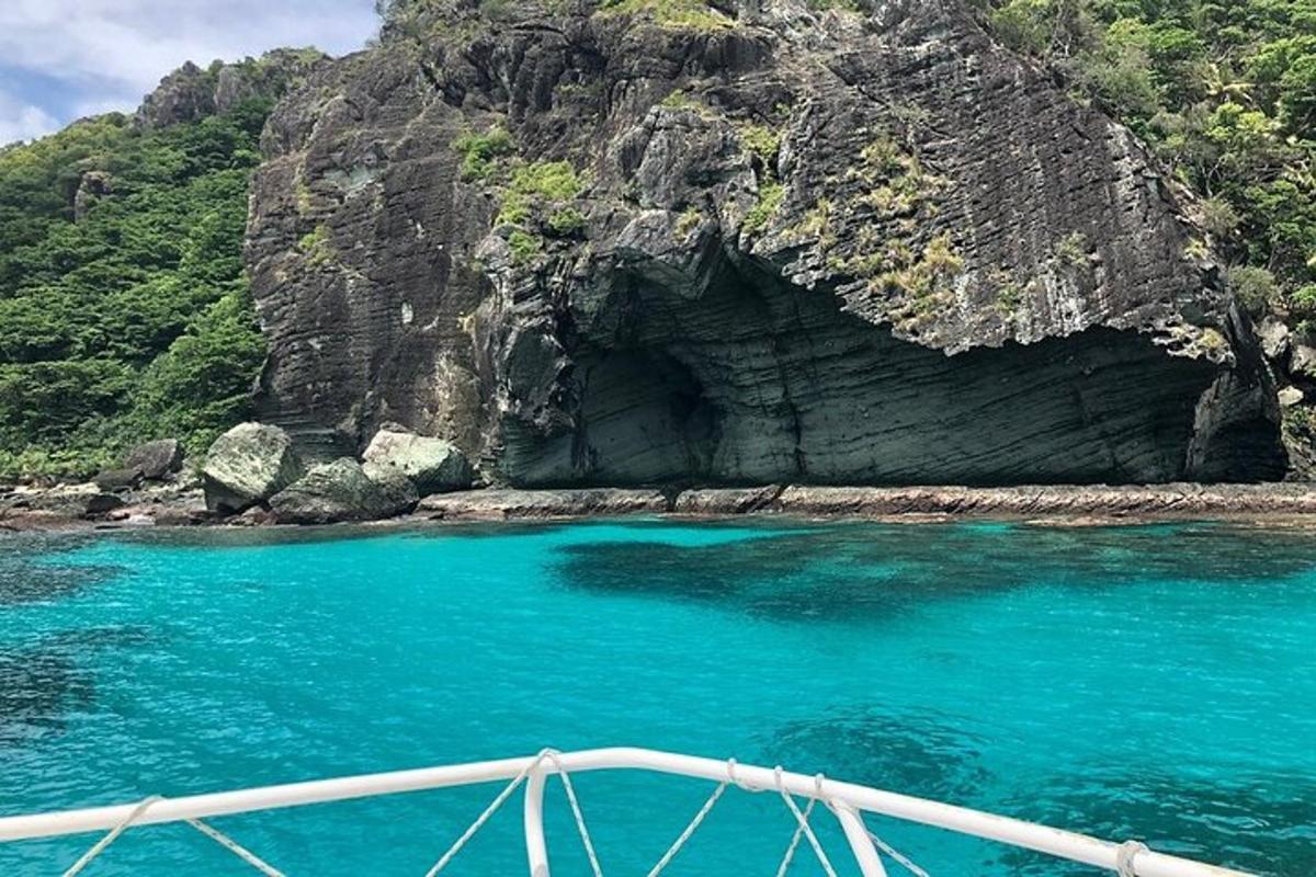 a boat in a body of water next to a cave