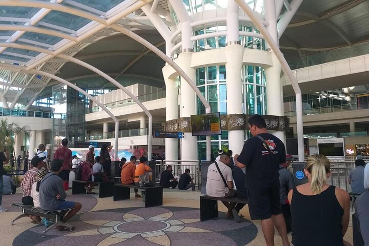 sekumpulan orang berdiri di terminal lapangan terbang