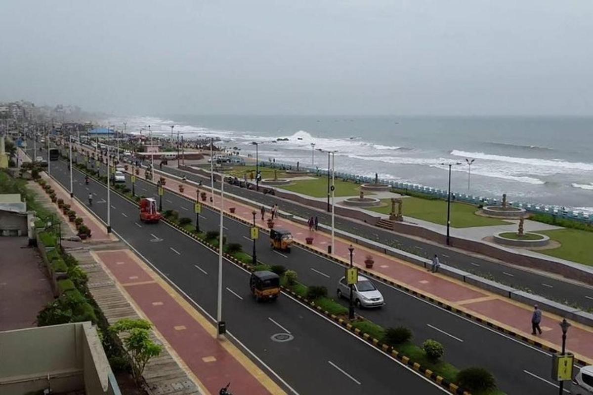 a view of a street with the ocean in the background