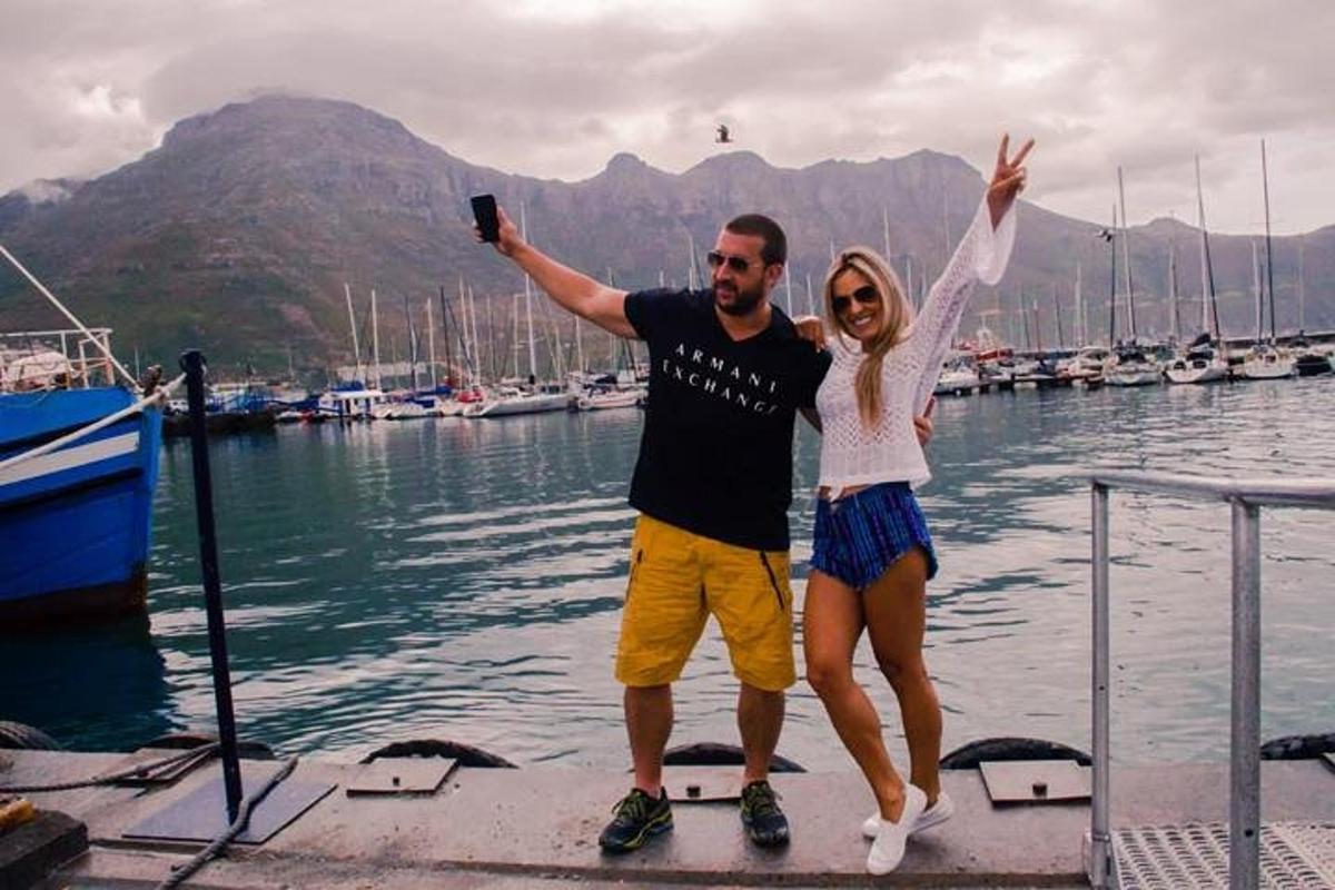 muž a žena stojící na molu s rukama ve vzduchu