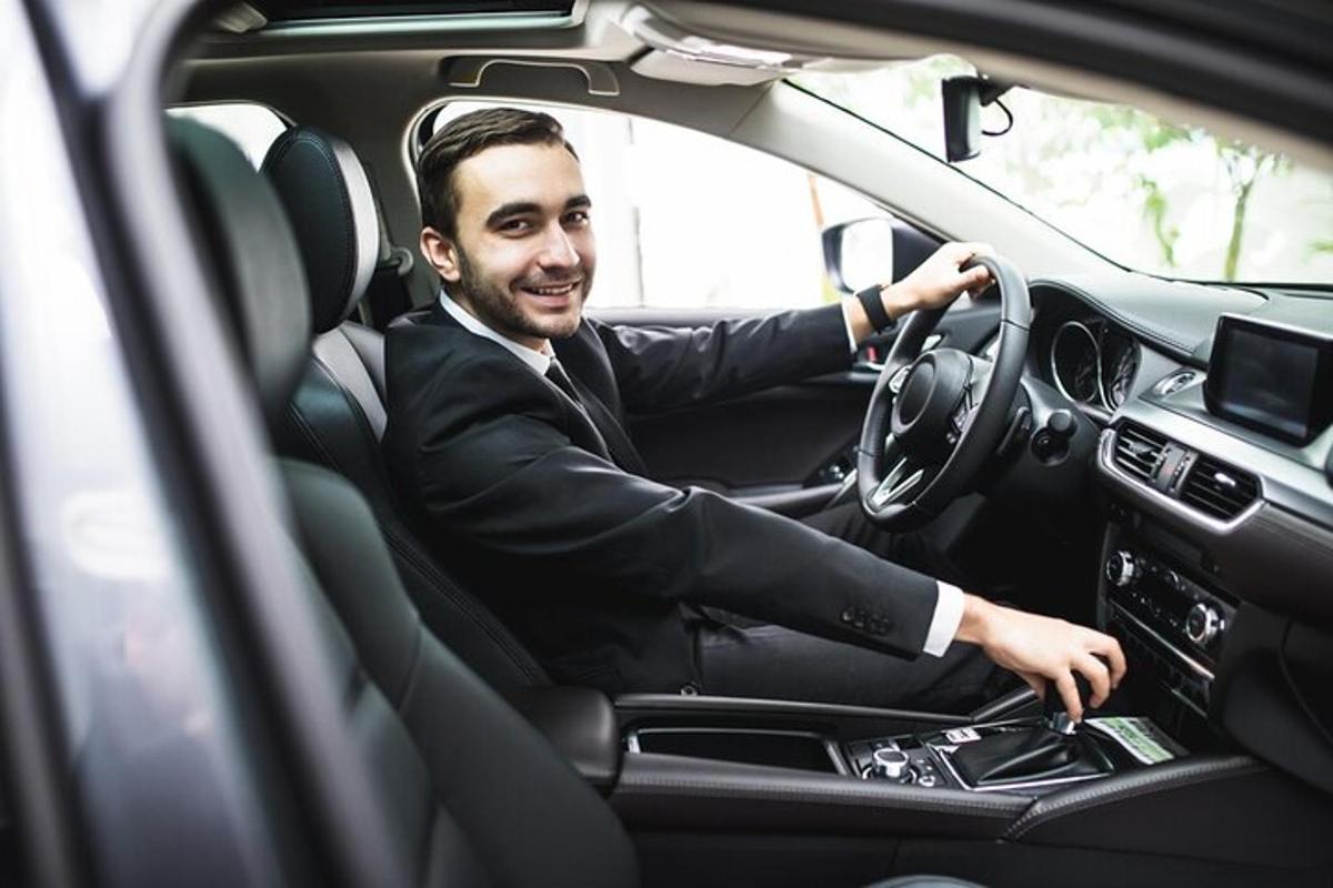 muž v obleku řídící auto