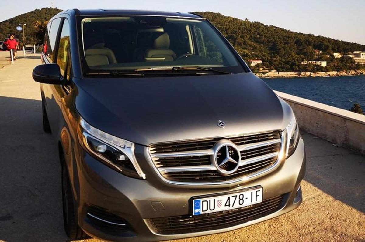 un'auto argentata parcheggiata accanto a uno specchio d'acqua