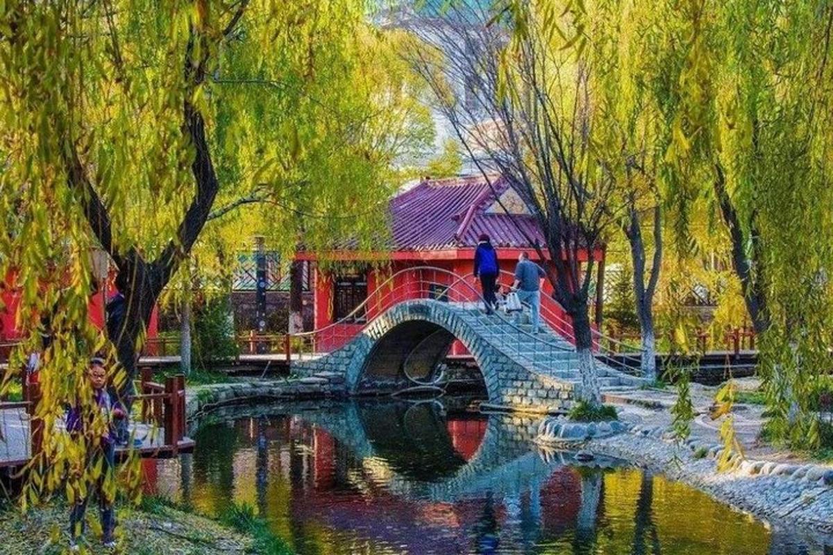 a painting of a bridge over a river in a park