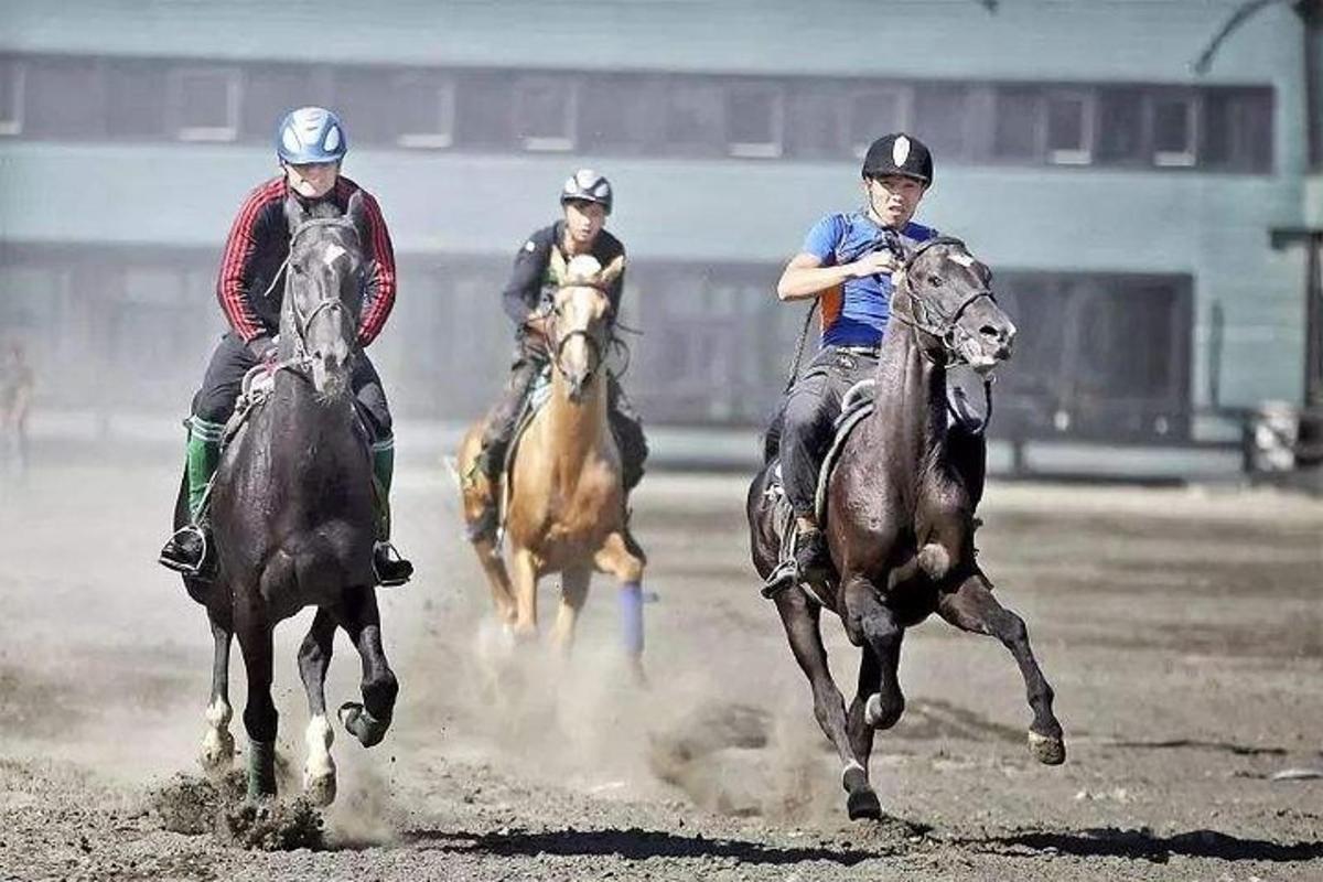 three people riding horses on a dirt track