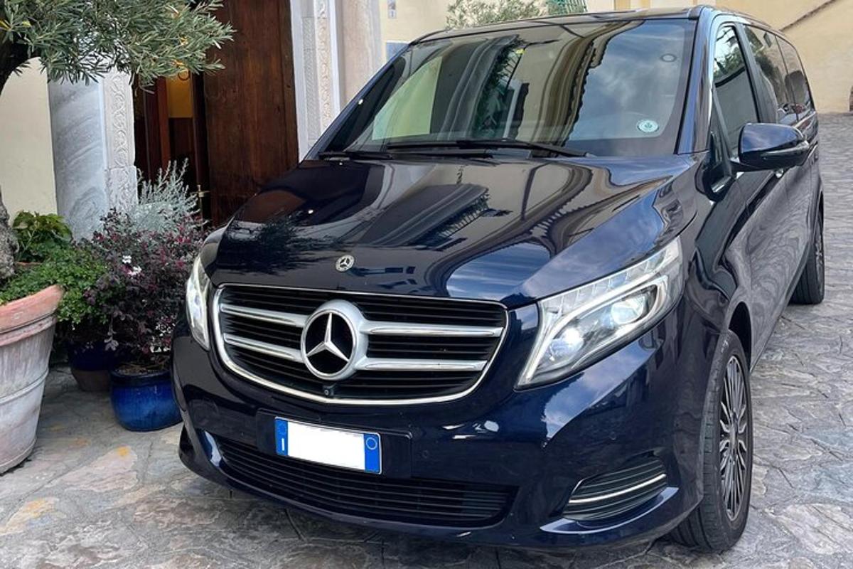 mobil Mercedes Benz hitam terparkir di jalan masuk