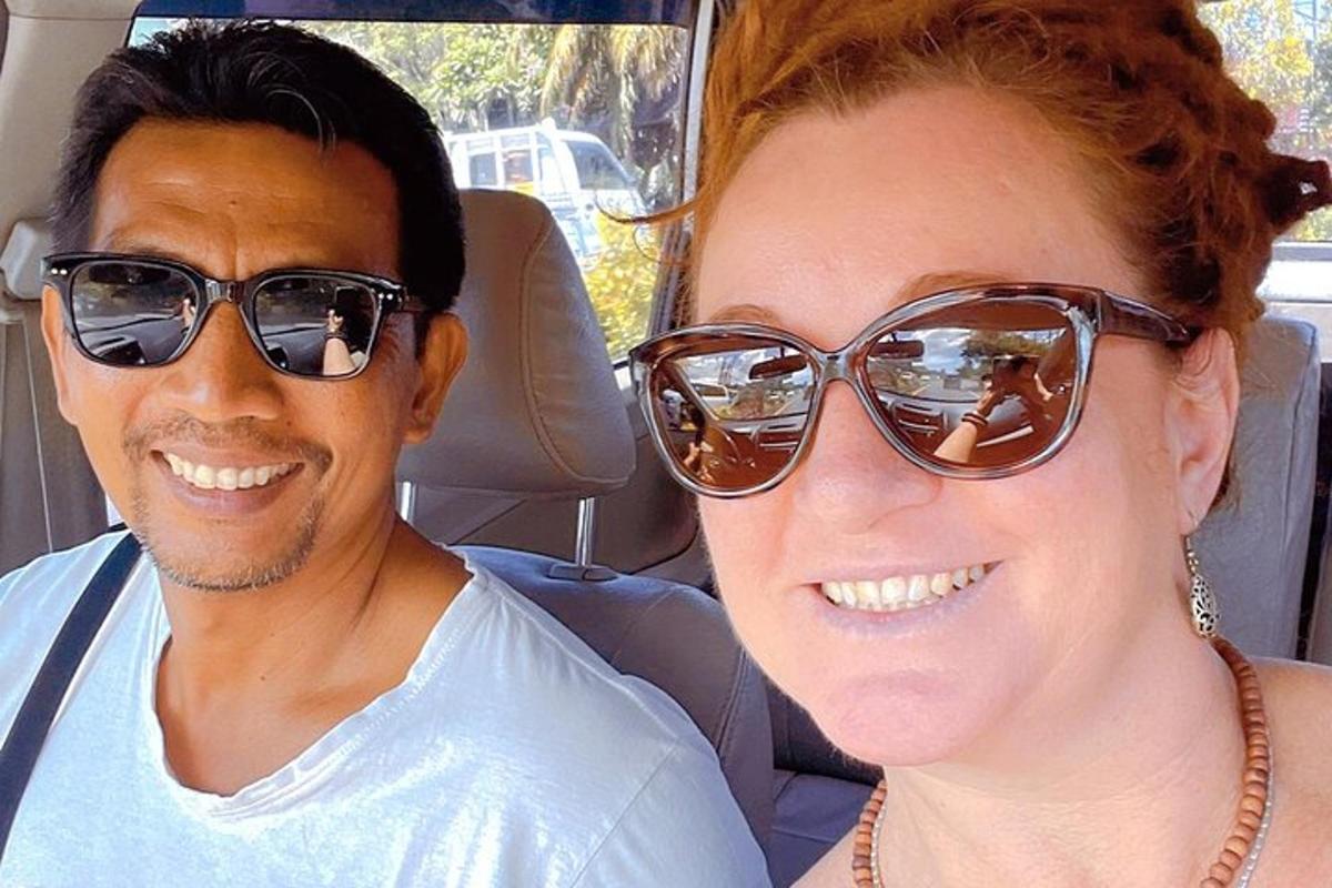 Ein Mann und eine Frau sitzen in einem Auto und tragen Sonnenbrillen
