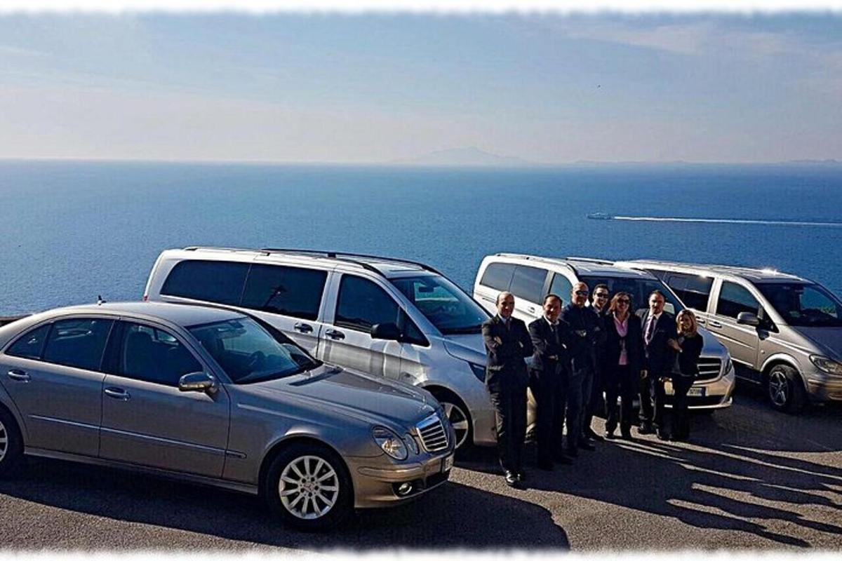 a group of people standing next to parked cars