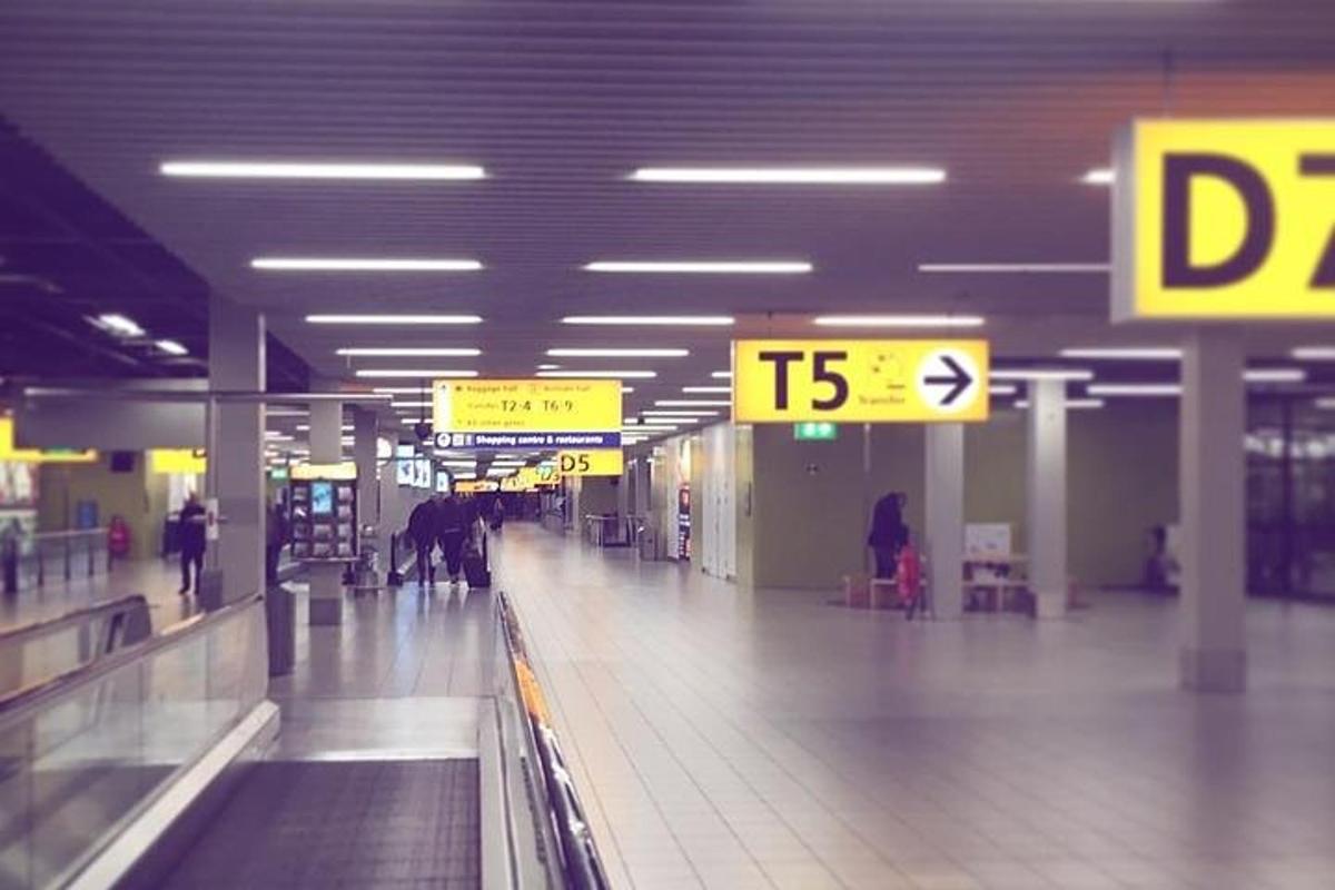 人々が歩き回っている空港の手荷物受取所