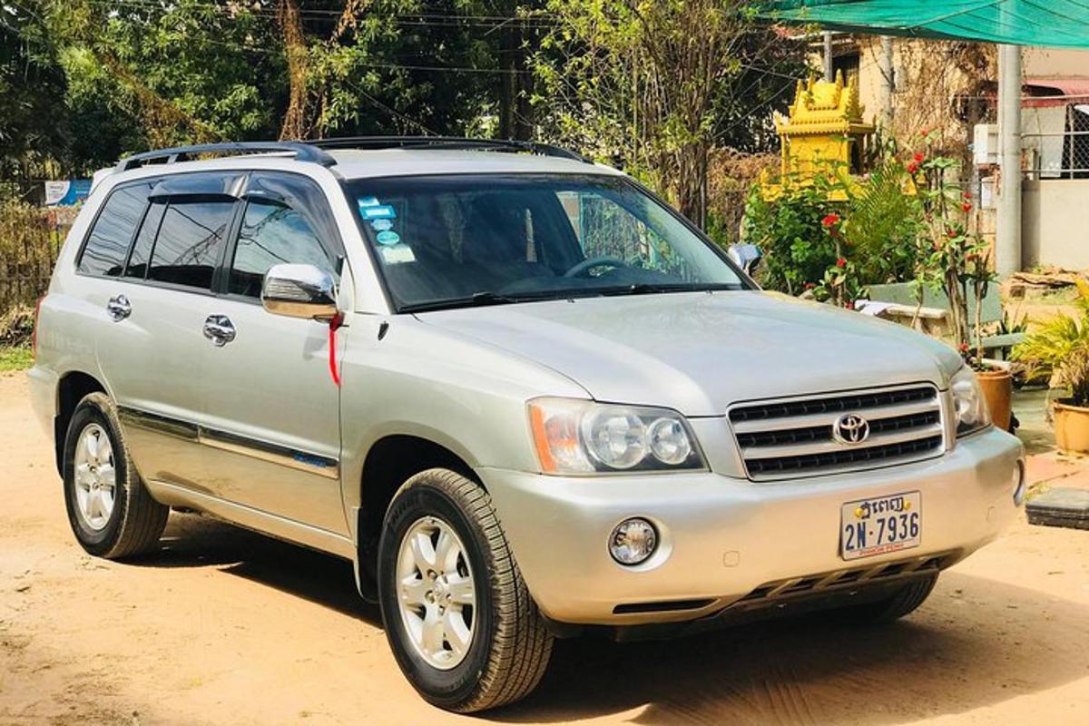 um SUV prateado estacionado em uma estrada de terra