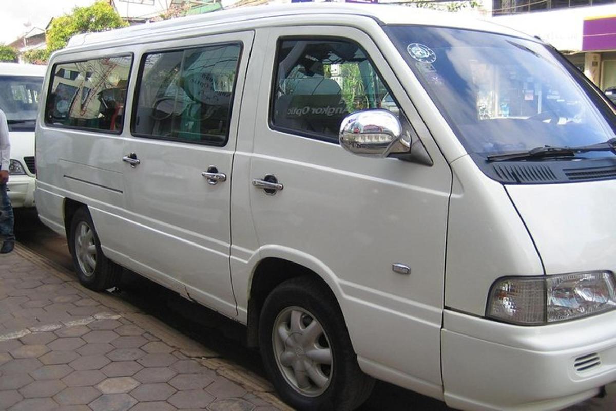 uma van branca estacionada na beira de uma rua