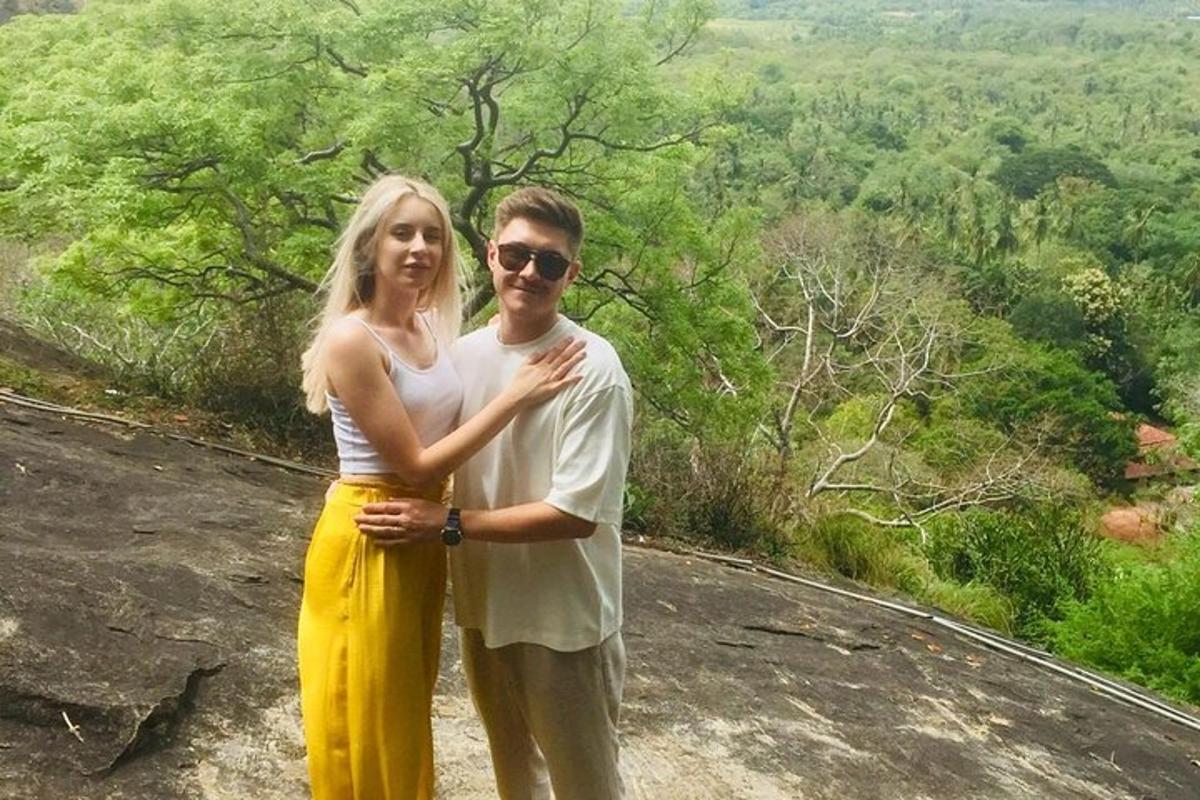 a man and a woman standing on top of a mountain