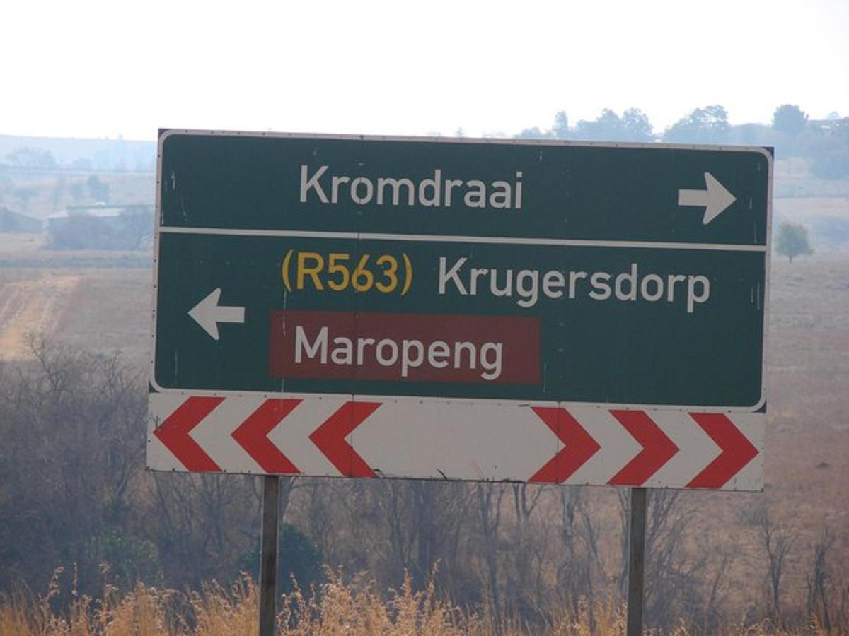 een groen-wit bord langs de kant van de weg