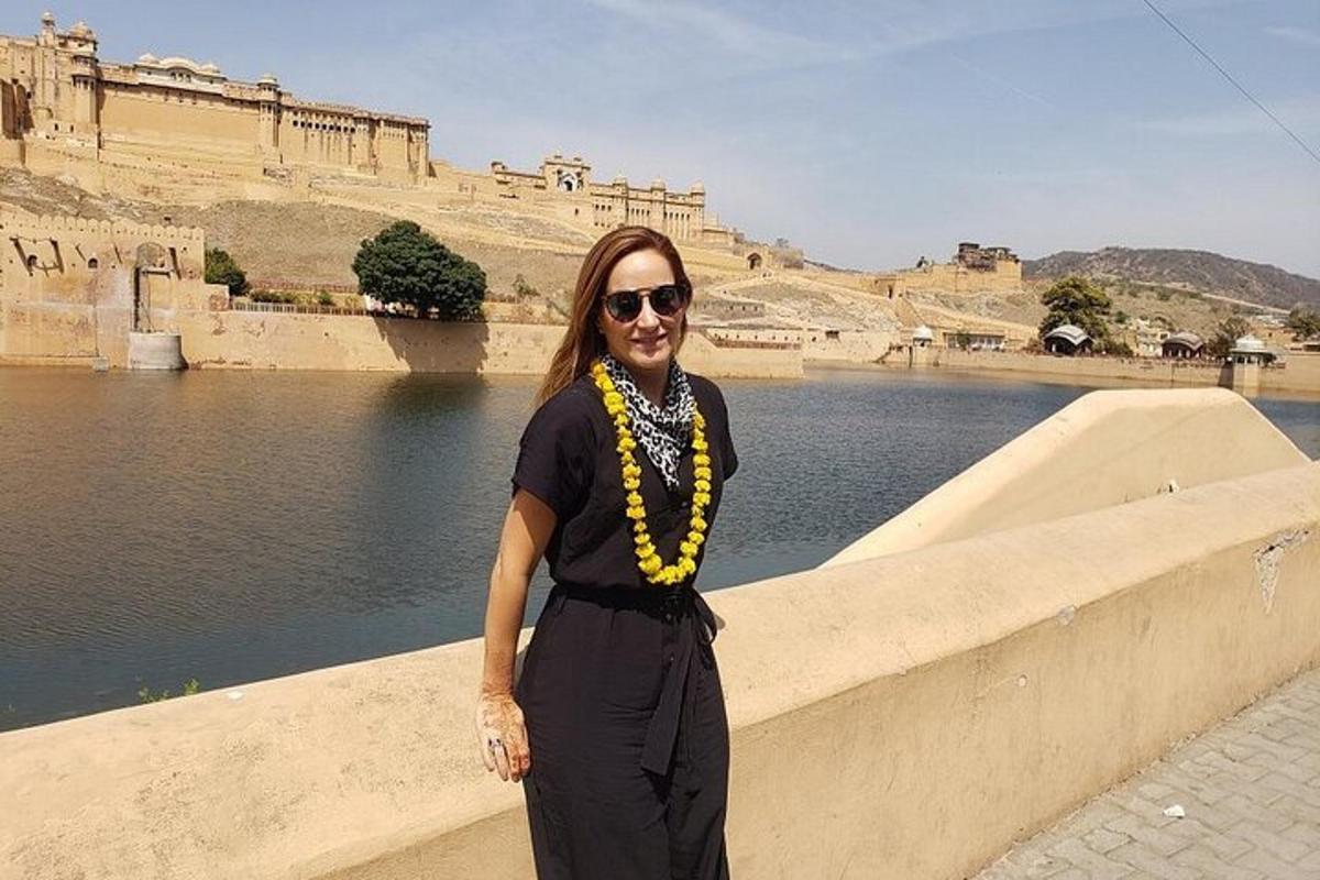 a woman standing next to a wall near a body of water