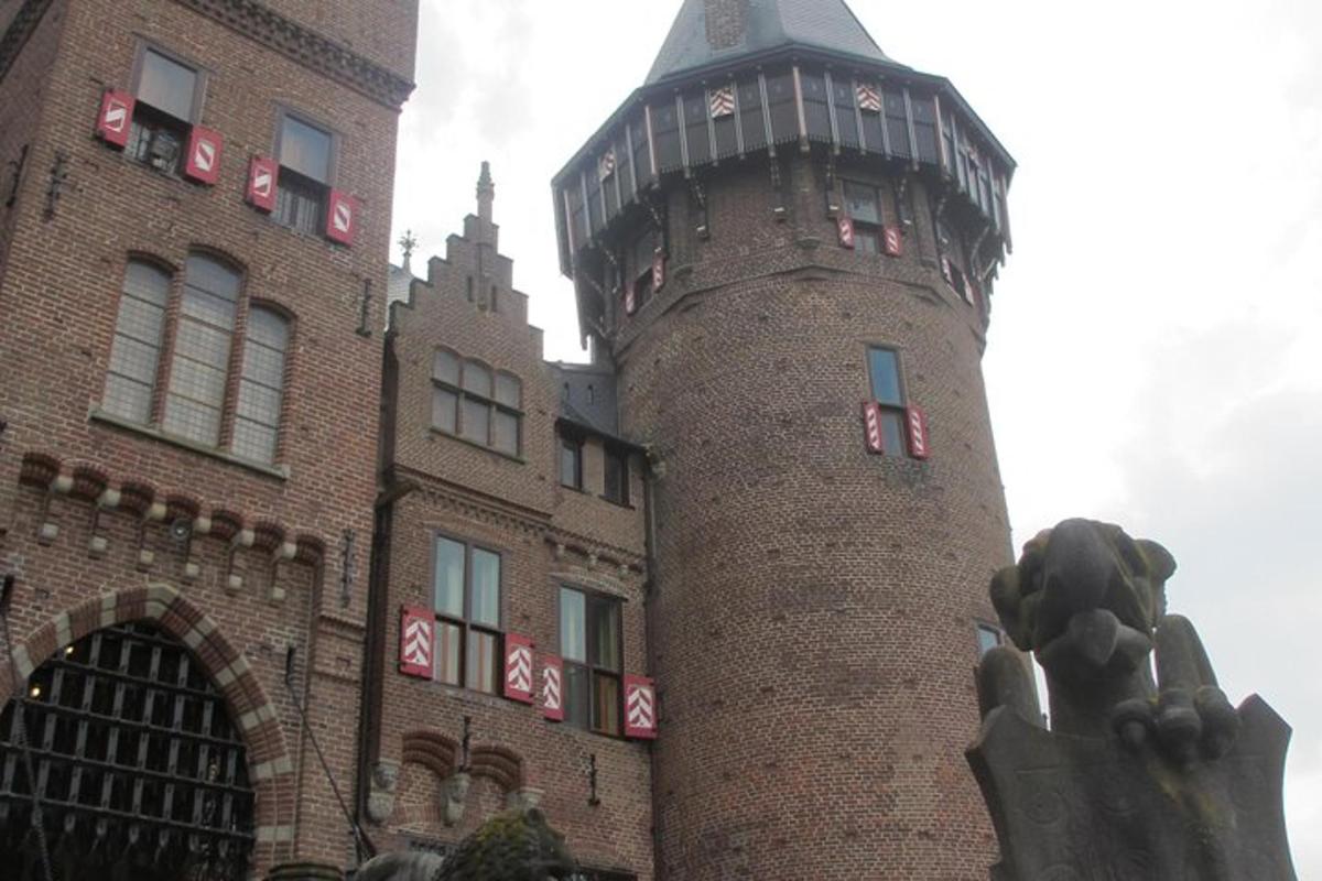 un edificio con una torre de reloj al lado de una estatua