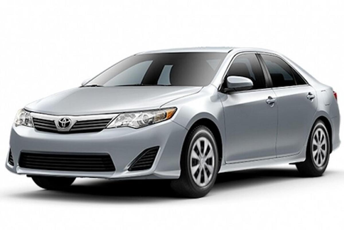 Silfurlitaður Toyota Avalon Hybrid bíll lagður fyrir framan hann
