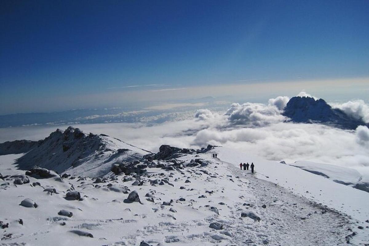 un gruppo di persone in piedi sulla cima di una montagna coperta di neve