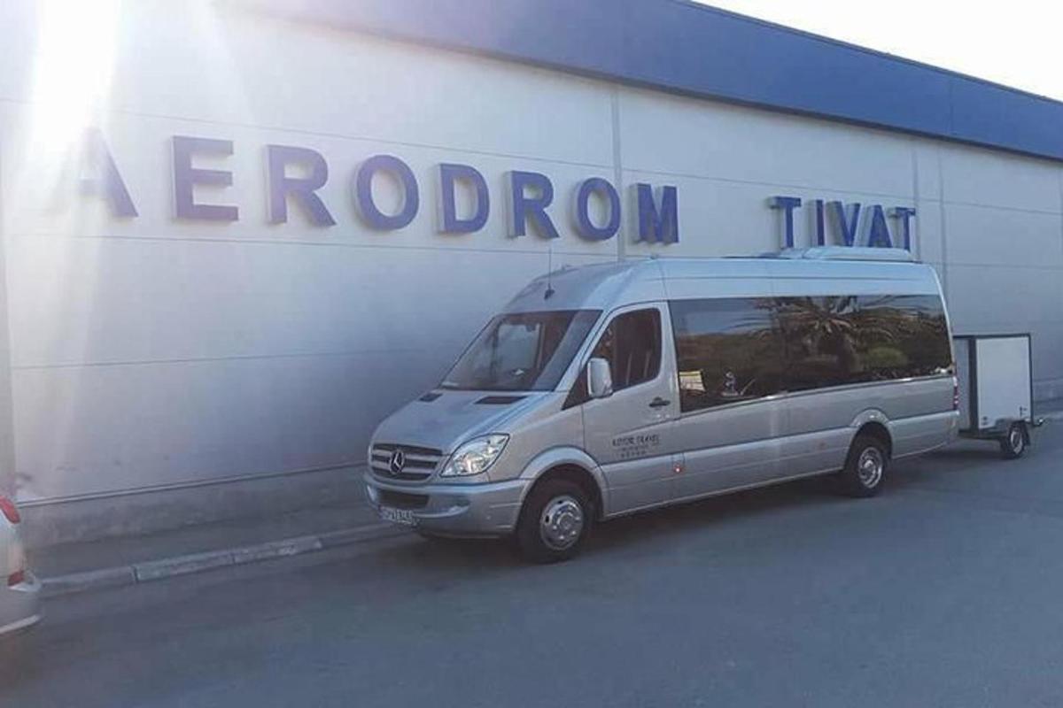 stříbrná dodávka zaparkovaná před budovou
