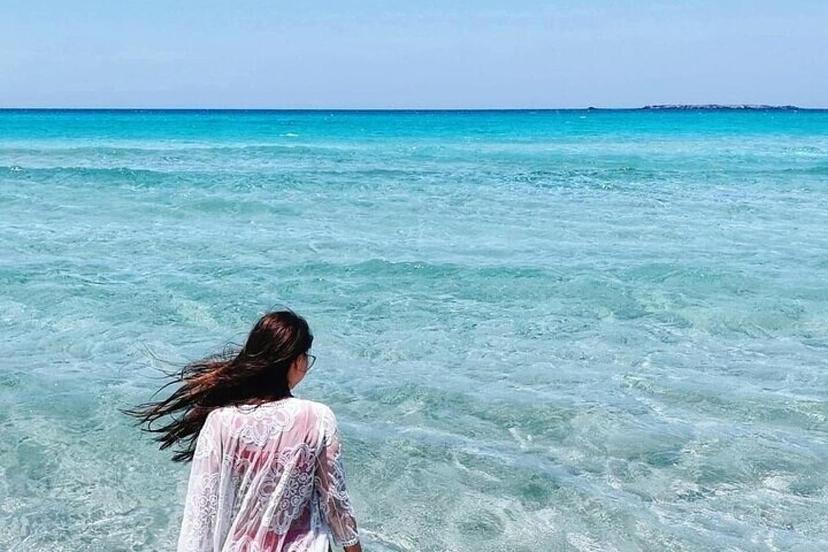a woman walking in the water at the beach
